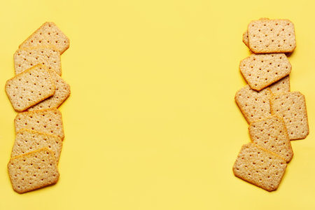 Frame made of tasty crackers on yellow backgroundの写真素材