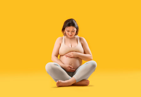 Young pregnant woman on color backgroundの写真素材