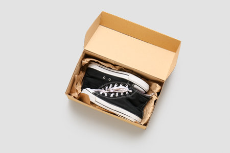 Cardboard box with casual shoes on light backgroundの写真素材