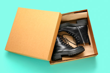 Cardboard box with stylish shoes on turquoise backgroundの写真素材