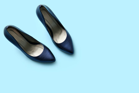 Pair of stylish high heeled shoes on light blue backgroundの写真素材