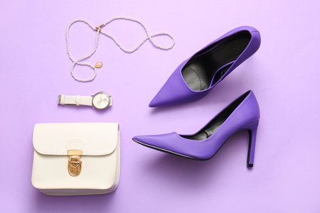 Stylish high heeled shoes and accessories on lilac backgroundの写真素材