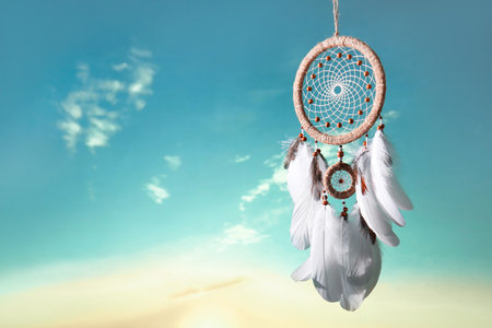 Beautiful dream catcher hanging against blue skyの写真素材