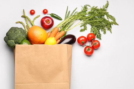 Paper bag with vegetables and fruits on gray backgroundの写真素材