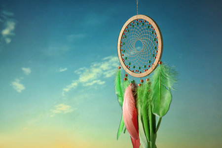 Beautiful dream catcher hanging against blue skyの写真素材
