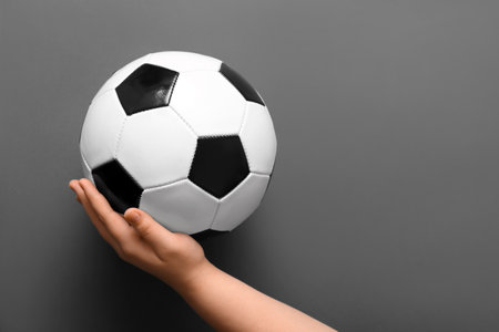 Hand with soccer ball on gray backgroundの写真素材