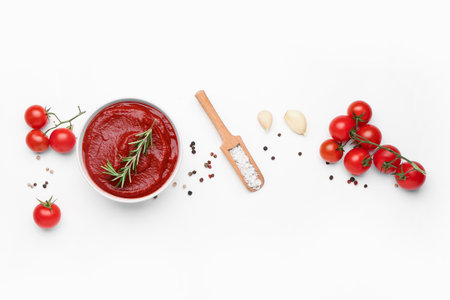 Bowl with tasty tomato paste, garlic and spices on white backgroundの写真素材