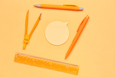 Composition with sticky note, pens and ruler on yellow backgroundの写真素材