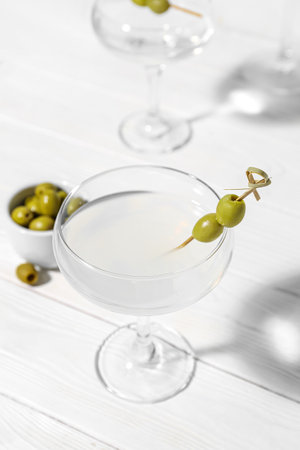 Glasses of martini with olives on white wooden backgroundの写真素材