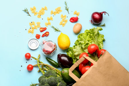 Paper bag with vegetables and fruits on light blue backgroundの写真素材