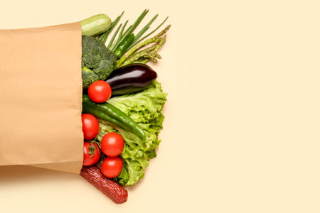 Paper bag with vegetables and sausage on beige backgroundの写真素材