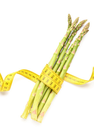 Asparagus and yellow measuring tape on white background. Diet conceptの写真素材