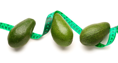 Avocados and green measuring tape on white background. Diet conceptの写真素材