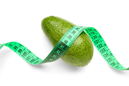Avocado and green measuring tape on white background. Diet conceptの写真素材