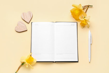 Composition with blank notebook and flowers on yellow backgroundの写真素材