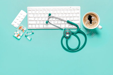 Stethoscope, pc keyboard, coffee and drugs on turquoise backgroundの写真素材