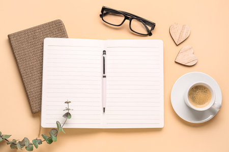 Composition with blank notebook, coffee cup and glasses on beige backgroundの写真素材