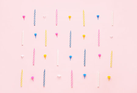 Colorful birthday candles on pink backgroundの写真素材