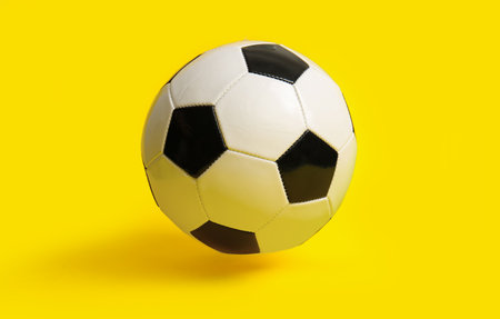 soccer ball on yellow backgroundの写真素材