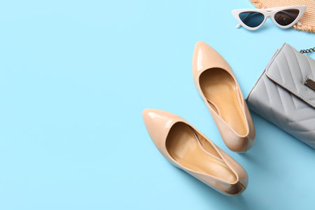 Stylish high heeled shoes and accessories on light blue backgroundの写真素材