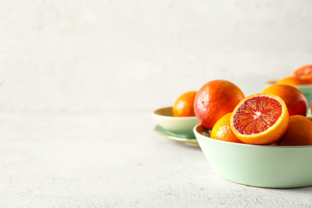 Bowl with tasty blood oranges on light backgroundの写真素材