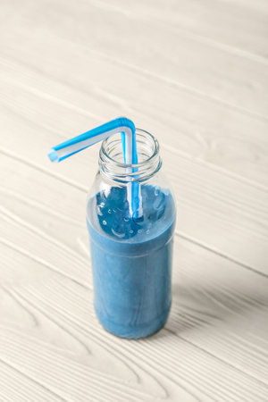 Glass bottle of blue smoothie on white backgroundの写真素材