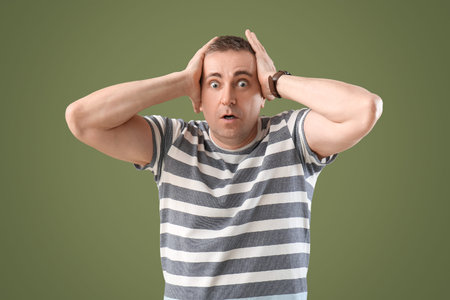 Scared mature man on green background