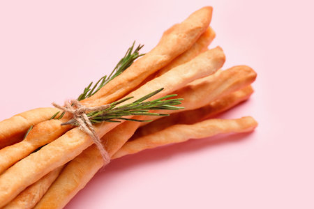 Bunch of tasty Italian Grissini on pink background, closeup