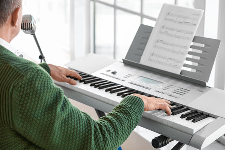 Mature singer playing synthesizer at homeの写真素材