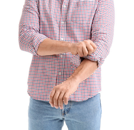 Mature man rolling up his sleeve on white background, closeupの写真素材