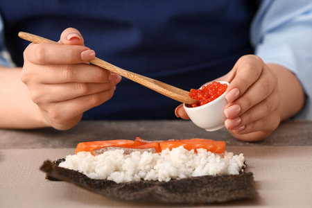 Woman preparing sushi rolls at table, closeupの写真素材
