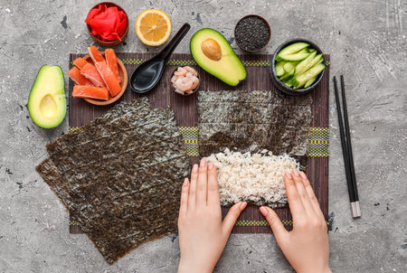 Woman preparing sushi rolls on grunge backgroundの写真素材