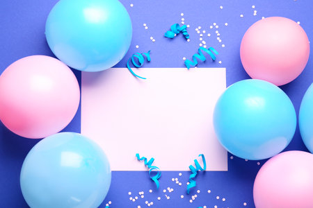 Frame made of balloons, ribbons, serpentine and blank paper sheet on color backgroundの写真素材