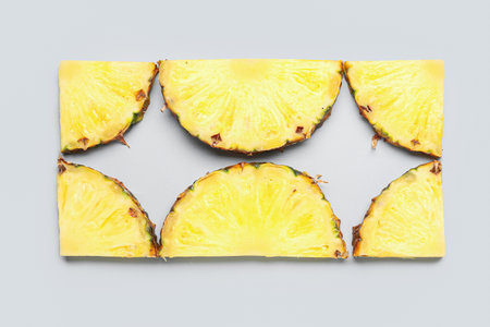 Slices of fresh ripe pineapple on gray backgroundの写真素材