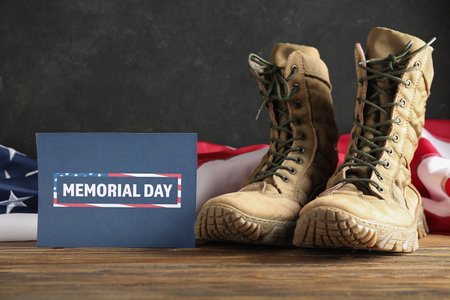 Greeting card for Memorial Day celebration with USA flag and military boots on wooden tableの写真素材