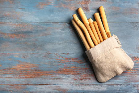 Sack bag with tasty Italian Grissini on blue wooden backgroundの写真素材