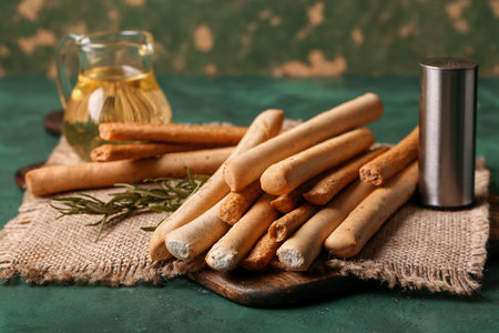 Wooden board with tasty Italian Grissini on tableの写真素材