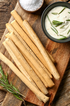 Board with tasty Italian Grissini on wooden backgroundの写真素材