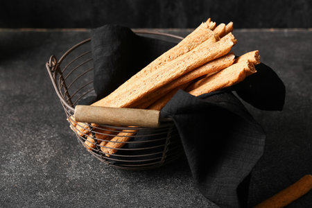 Basket with tasty Italian Grissini on dark backgroundの写真素材