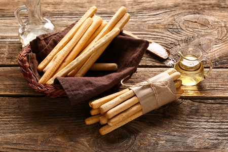 Wicker basket with tasty Italian Grissini on wooden backgroundの写真素材