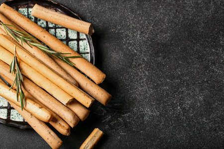 Plate with tasty Italian Grissini on dark background, closeupの写真素材