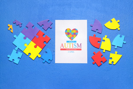 Card for World Autism Awareness Day with puzzle pieces on blue backgroundの写真素材