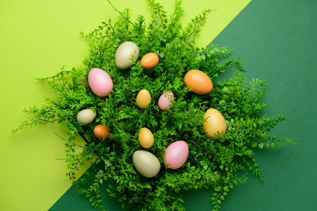 Easter eggs and plant leaves on green backgroundの写真素材
