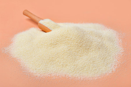 Heap of raw semolina on pink backgroundの写真素材