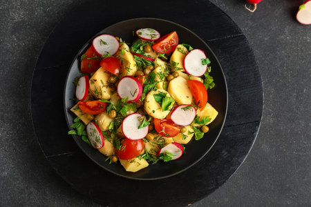 Plate of tasty Potato Salad with vegetables on dark backgroundの写真素材