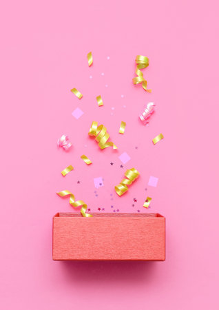 Composition with wooden box and confetti on pink background