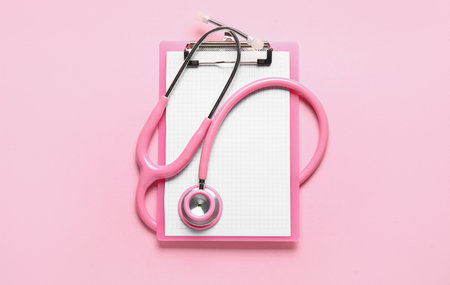 Stethoscope and clipboard on pink backgroundの写真素材