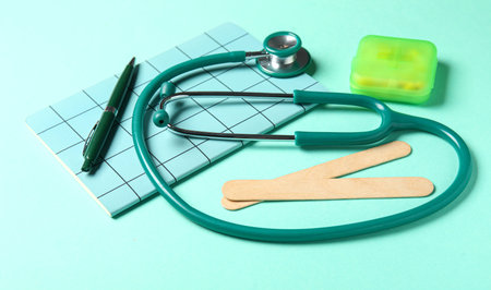 Stethoscope, notebook and pills on turquoise backgroundの写真素材