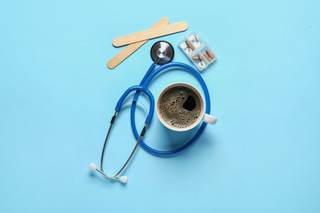 Stethoscope, coffee, pills and spatulas on blue backgroundの写真素材