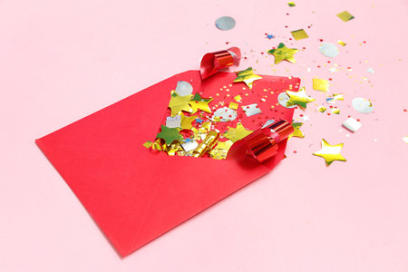 Composition with envelope and confetti on pink backgroundの写真素材
